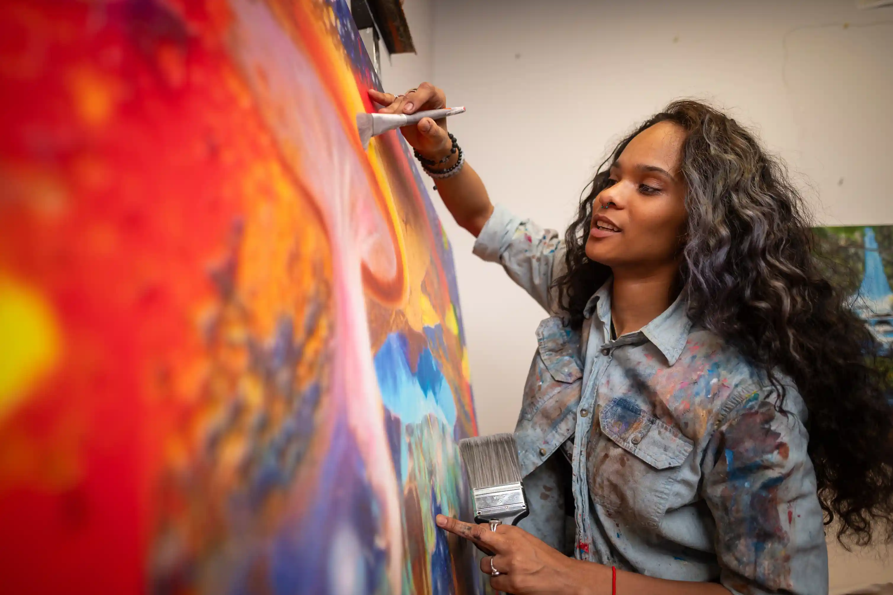 A women painting a canvas.