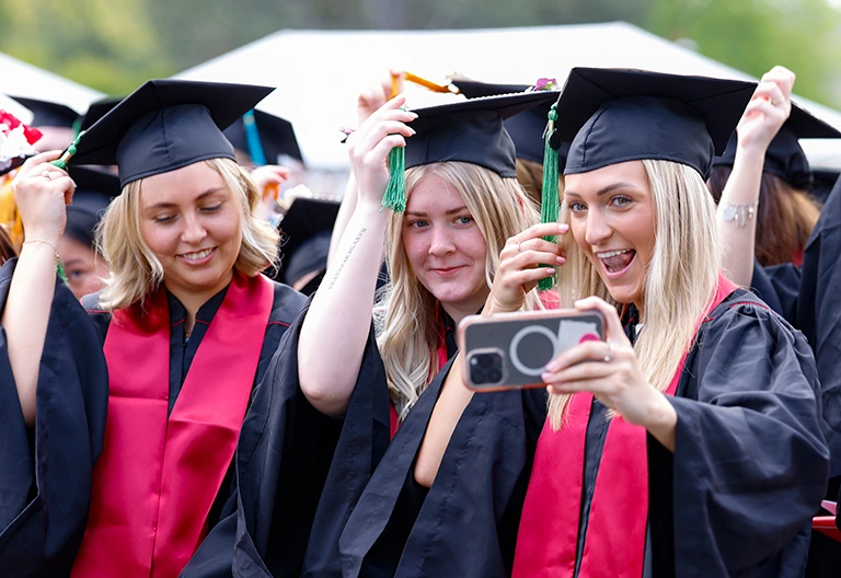 A group of female graduates smiling for a photo.