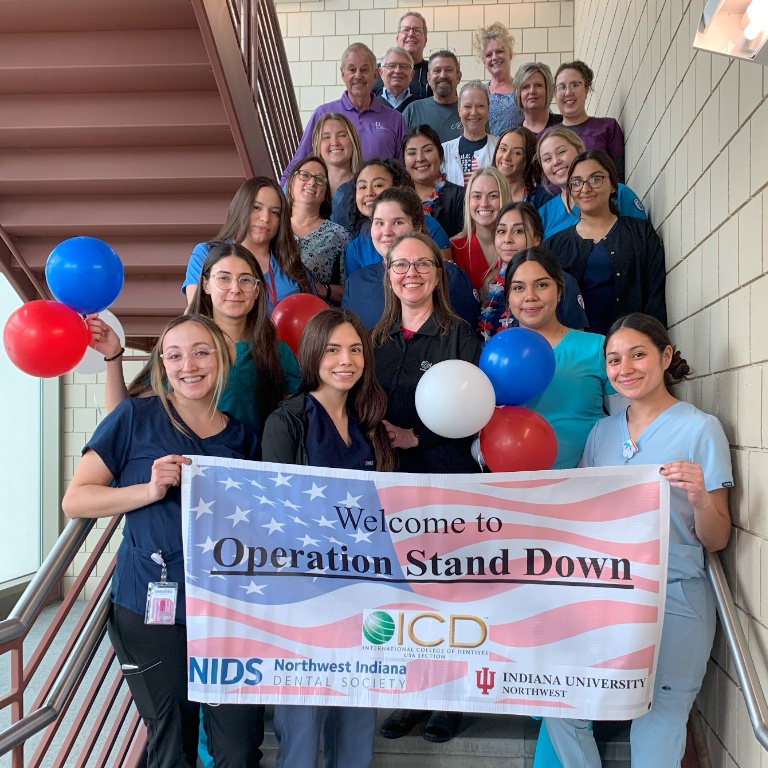 A group of students and faculty holding a banner.