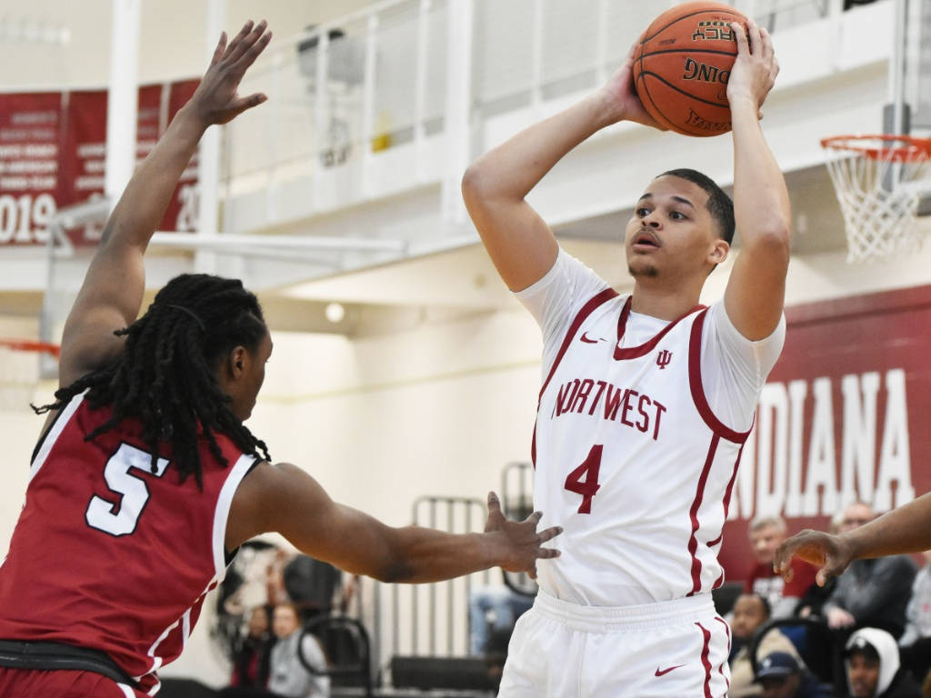 A men's basketball player holds a ball.