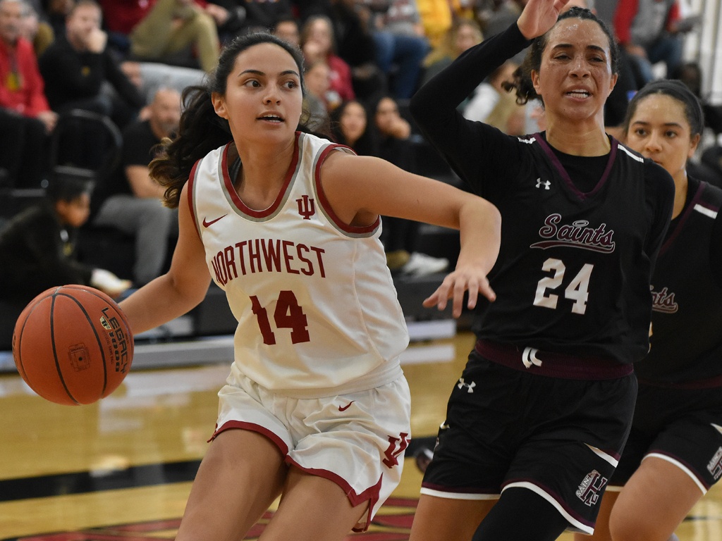 A women's basketball player dribbles a ball.