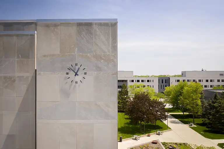 Scenic view of campus with clock in the foreground